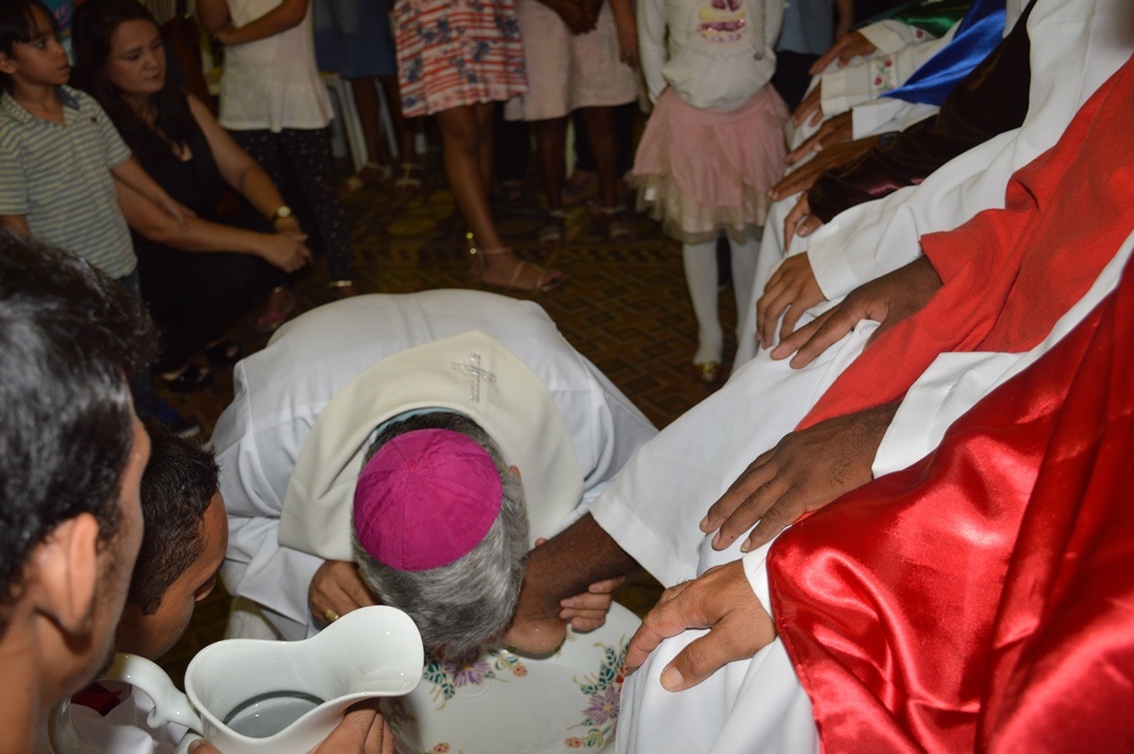 Dom Plínio beija os pés de homem da comunidade