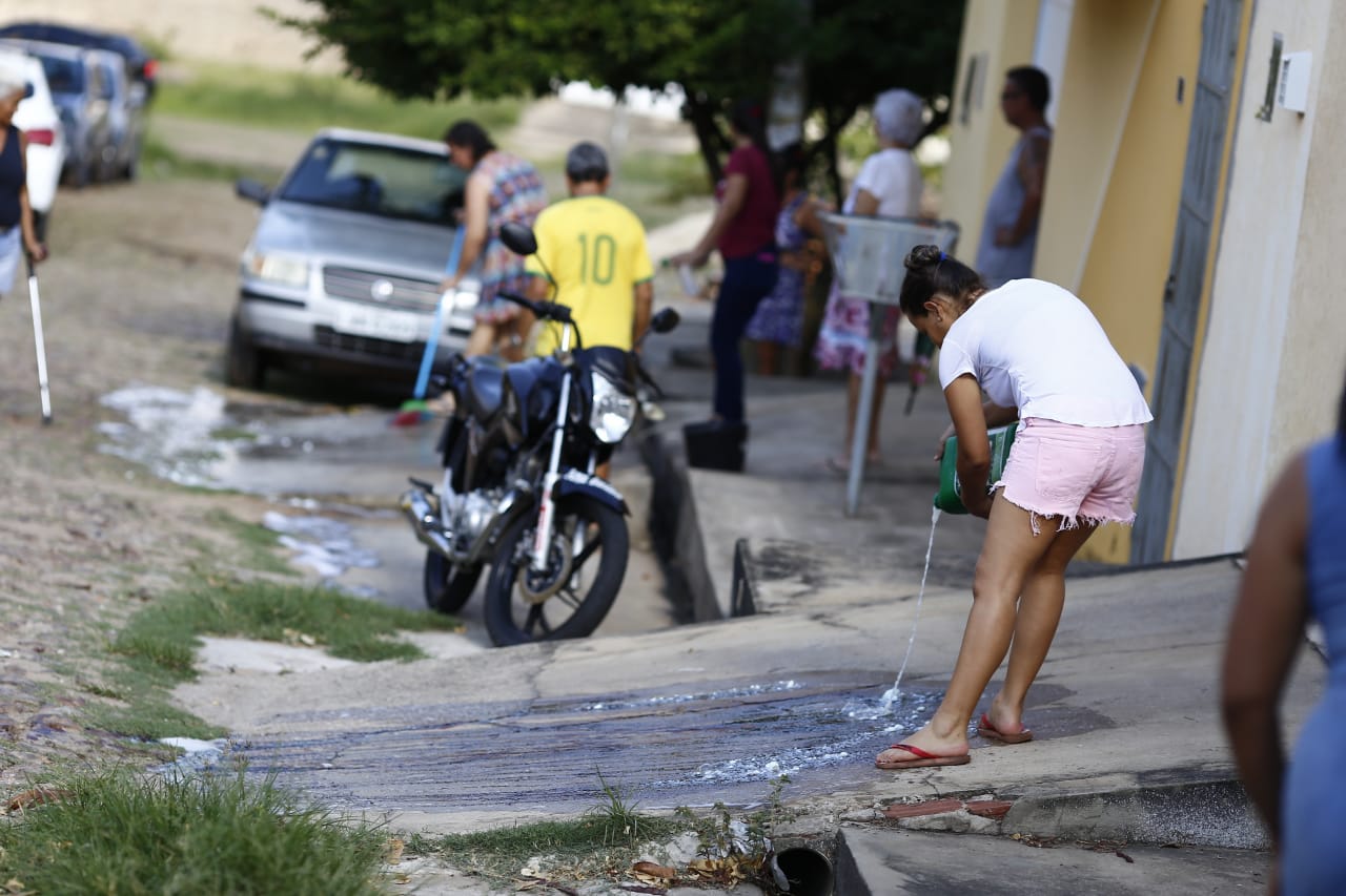 Populares limpando as marcas de sangue da residência