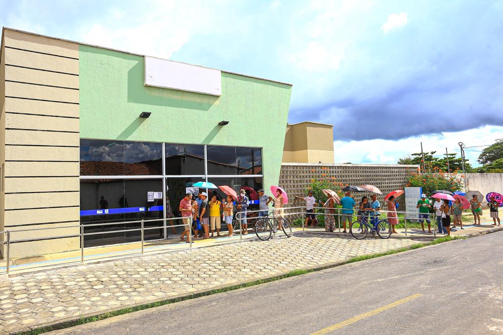 Idosos em fila no sol quente 
